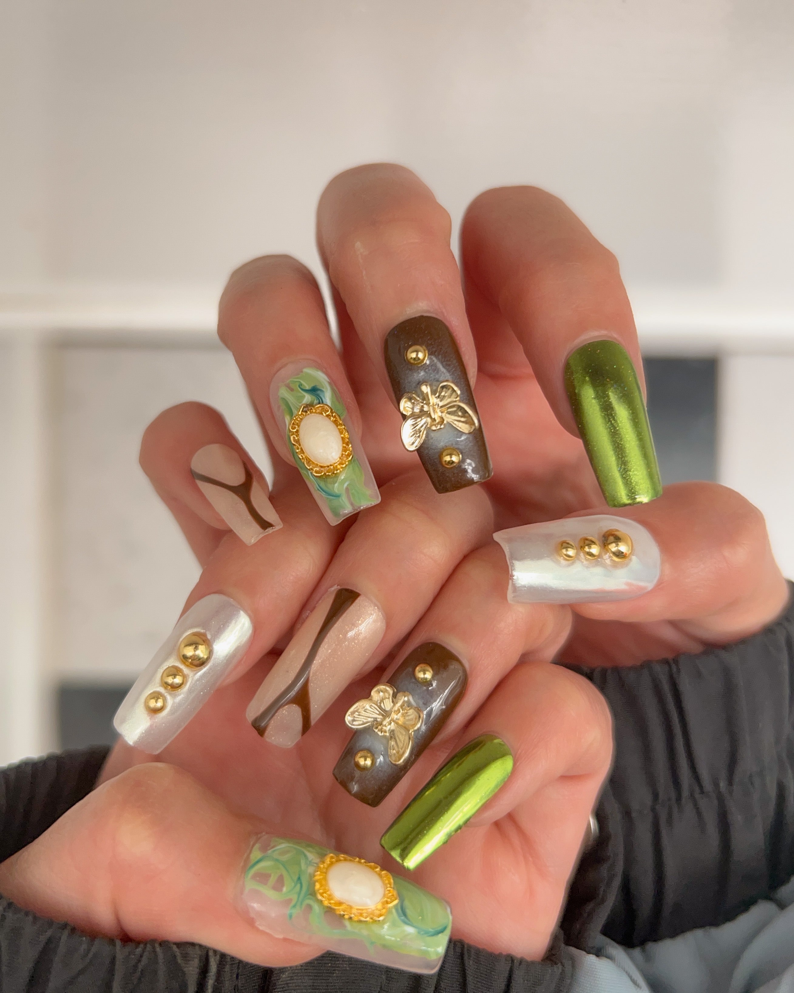 Premium Photo | A green and gold nail art design with a gold leaf